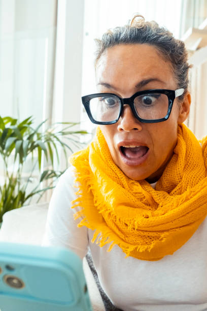 istock Astonished and surprised expression of woman using mobile phone. Virus or bad notification. Email and fraud website scam online. User lost password and security. Concept of clickbait and online fraud 2154832801