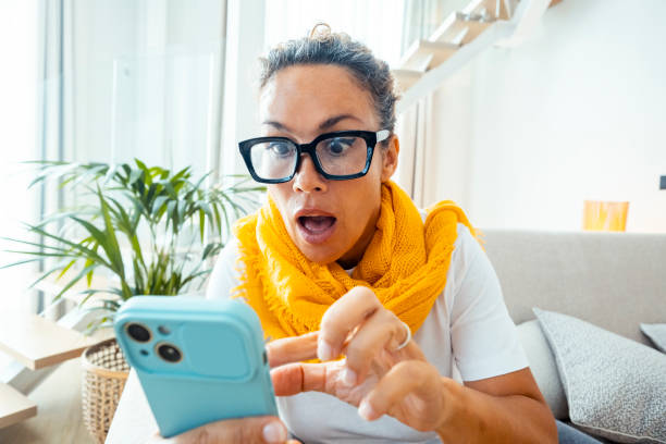 Astonished and surprised expression of woman using mobile phone. Virus or bad notification. Email and fraud website scam online. User lost password and security. Concept of clickbait and online fraud