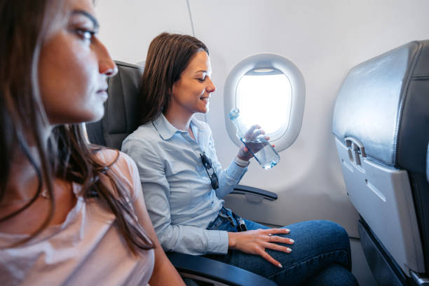istock Young Woman Drinking Water In An Airplane 2154835432