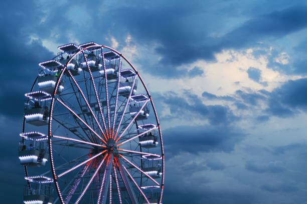 Ferris wheel for panoramic view in amusement park is popular entertaining ride in summer evening, selective focus