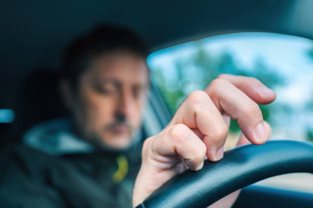 istock Nervous driver tapping fingers on car steering wheel while waiting 2154836077