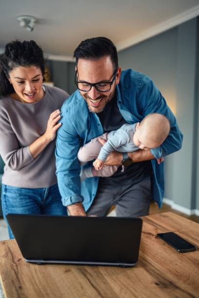 istock Family with a baby at home, Father using a laptop. 2154837829