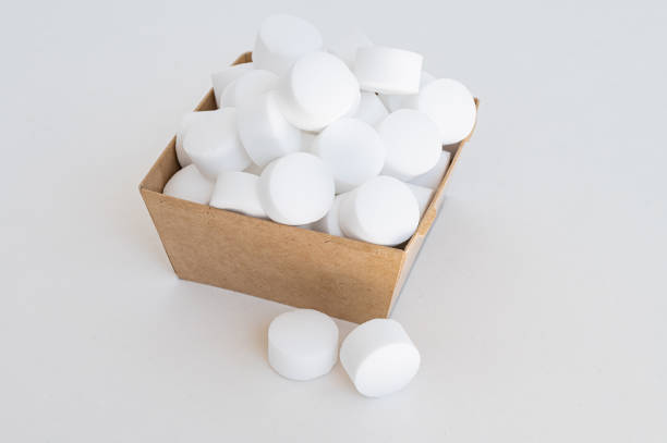 White tablets of pressed salt for the dishwasher close-up. Isolated capsules. Place for text