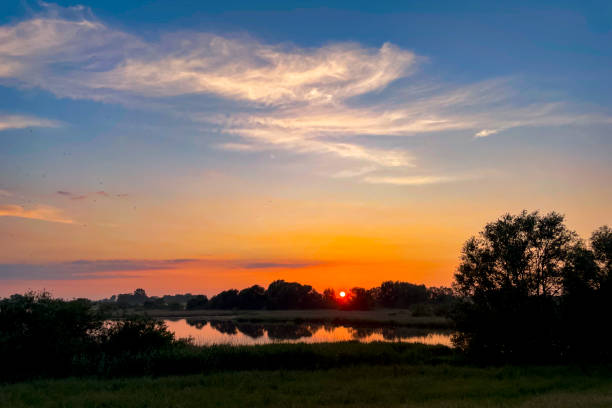 The river IJssel near Zwolle during a beautiful springtime sunset with high water level on te river and overflowing floodplains.