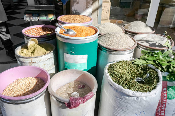 Algeria -December 29, 2022: legumes, dried herbs and spices displayed outside a store in a sunny  day with an old scale.