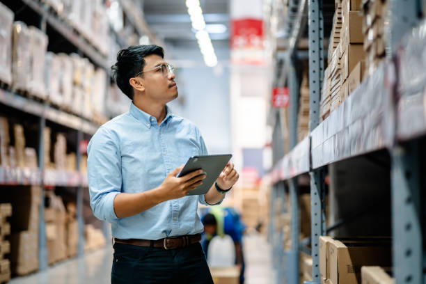 businessmen or manager use a digital tablet to check the stock inventory on shelves in large warehouses, a smart warehouse management system, supply chain and logistic network technology concept. - entregar imagens e fotografias de stock