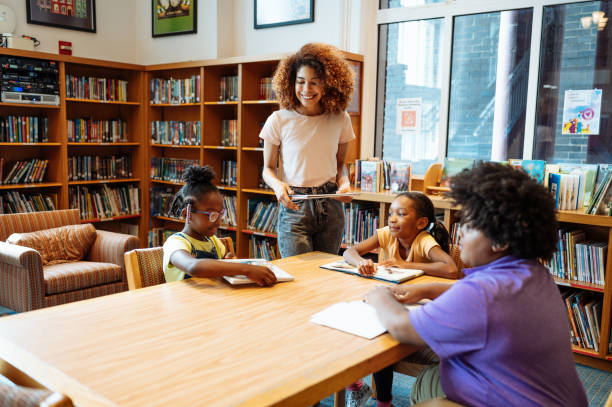 istock School children with teacher in library, having a reading class 2154842057
