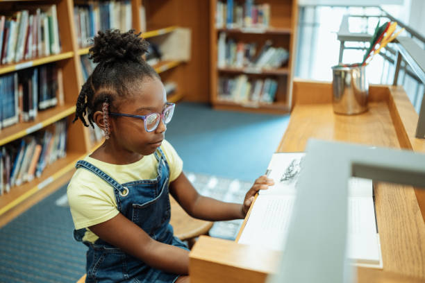 istock School children with teacher in library, having a reading class 2154842172