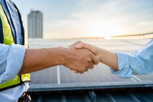 istock Two Electrical Engineers shaking hands after working to inspect the installation and maintenance of solar panels in the solar power station, Renewable Energy, sustainable business concept. 2154842540