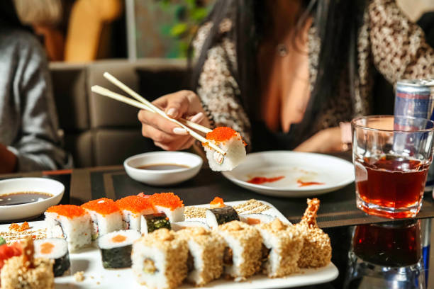istock Woman Eating Sushi With Chopsticks at a Restaurant 2154844085