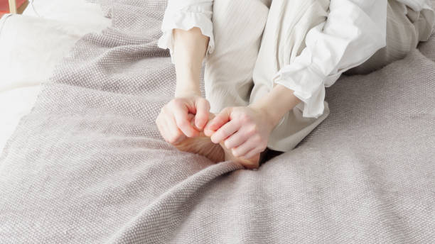 A woman rubbing her cold feet stock photo