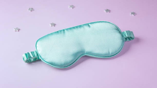 istock Silk sleep mask with stars on pastel purple background 2154846953