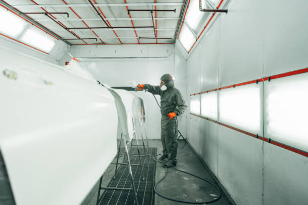 istock Auto painter painting a car with vaporizer gun inside a paint booth 2154847938