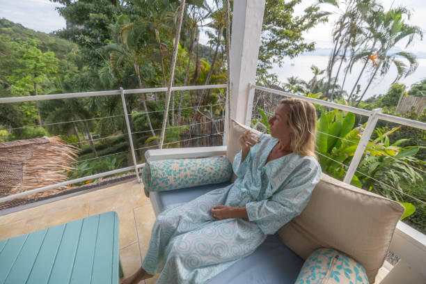 istock Woman relaxing with a drink on a balcony with a scenic view 2154848967