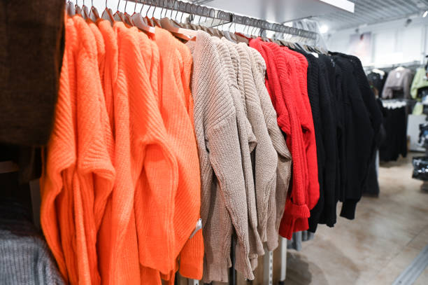 istock Multicolored sweaters on a hanger in the store 2154849358