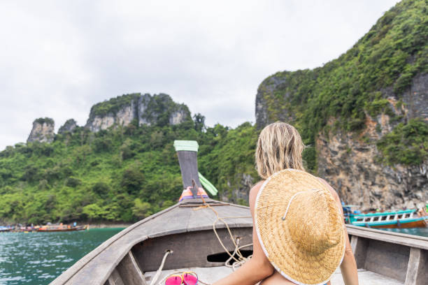 istock Woman Relaxing on Boat in Tropical Waters with Straw Hat 2154851925