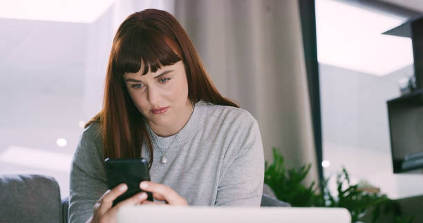 istock Phone, depression and woman on sofa for breakup scroll on social media, mobile app or internet for jealous. Sad, divorce and female person networking on cellphone in living room of apartment. 2154852933