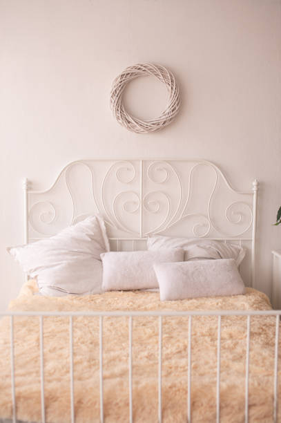 A bed with a cosy fur blanket and various pillows.