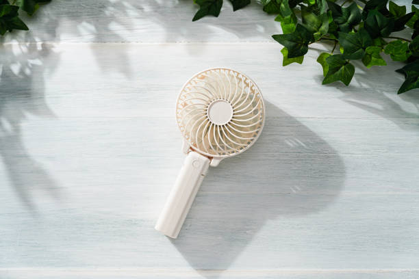 Portable electric fan on wooden table
