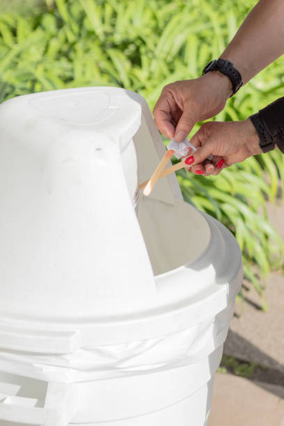 istock A couple throwing popsicle sticks into a trash can. Waste separation. 2154856000