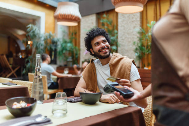 istock Young Man Paying for Meal at Restaurant 2154858821