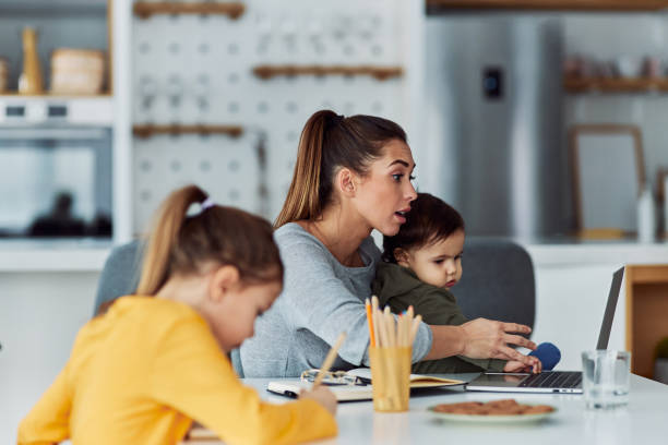 istock A hard-working mother having a video call on her laptop while working from home and looking after her kids 2154862247