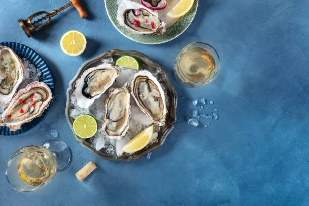 istock Oysters on ice, with various toppings and white wine, overhead flat lay shot 2154863983