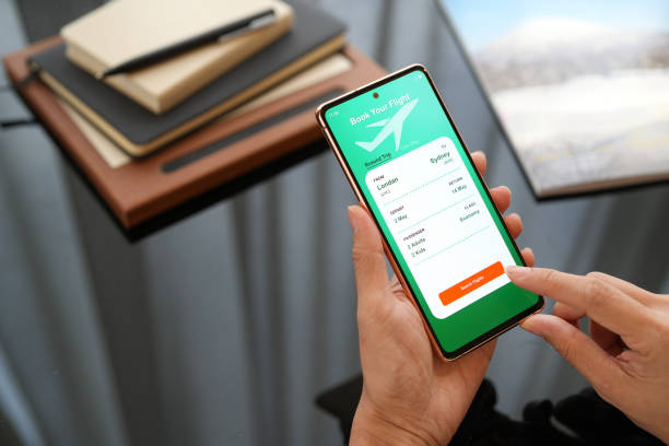 istock High angle view captures a woman using a smartphone application to book flight tickets and plan her holiday trip. 2154868226