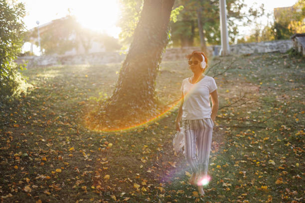 istock Woman enjoying music while walking in autumn nature 2154868889