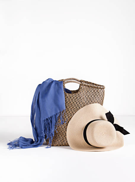 Beach accessories, straw bag and straw hat with beach towel on white background
