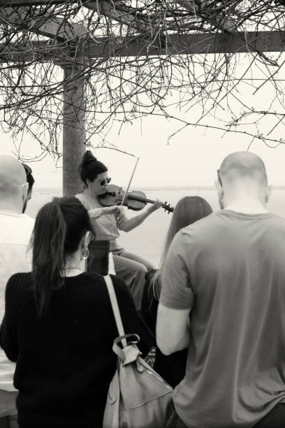Lisbon, Portugal - Mar 24, 2024: A street musician plays violin at a viewpoint in Lisbon downtown.