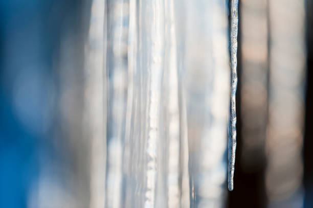 Numerous icicles are hanging from the side of a building in Norway, reflecting the regions cold climate. The sharp, transparent ice formations are slowly melting in the sun.