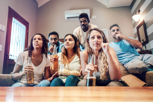 istock young people watching scocer match on tv together 2154877601