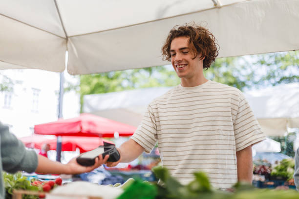 istock Young Man Paying at Farmer's Market with Card Reader 2154878168