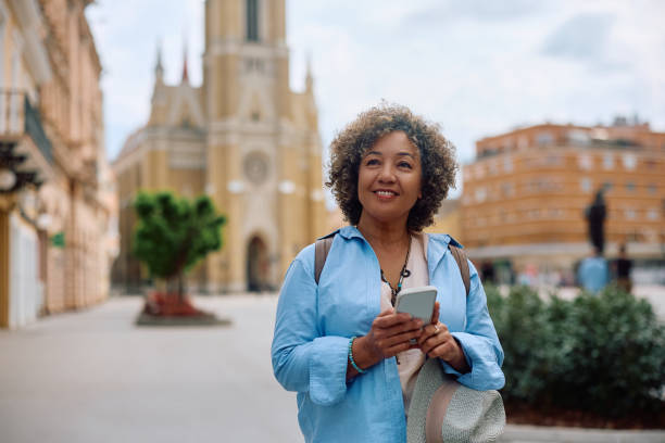 istock Happy female tourist using app on mobile phone while sightseeing in the city. 2154880295