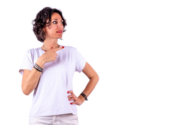 Selection, pointing, attention and choosing concepts. Short hair cute and beautiful woman with white shirt, pointing right side of frame. White background and large copy space.