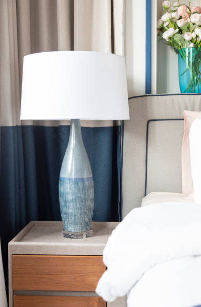 istock White bed with blue bedside table lamp, close-up. 2154881788