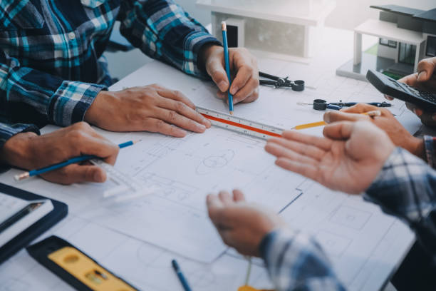 istock engineer people meeting working and pointing at a drawings in office for discussing. Engineering tools and construction concept. 2154881838