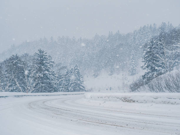 istock Winter snowstorm on a mountain road with dense forest in broad daylight 2154883155