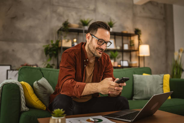 istock Adult man work from home on laptop and use mobile phone for message 2154884661