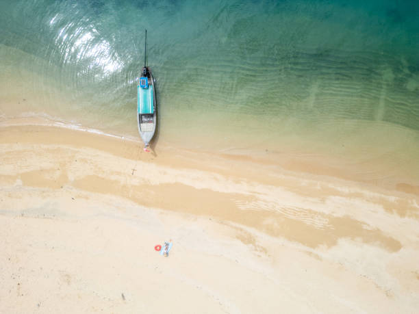 istock Aerial View of Boat Docked on Sandy Beach 2154885293