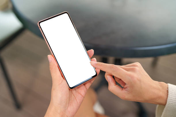 istock A woman sitting at backyard, hand holding a mobile smartphone with a blank screen. 2154885709