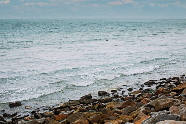 Rocky sea beach, waves crashing on the shore.
