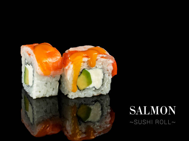 istock Side view of salmon sushi roll pieces isolated on black background. 2154894581