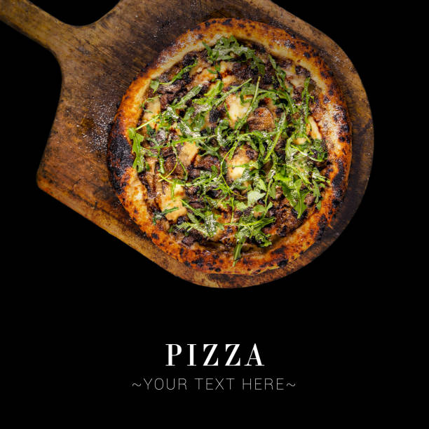 Top view of classic Italian uncut pizza with meat, mozzarella cheese and fresh arugula leaves served on baking shovel. Cheesy pizza isolated on black background with text and copy space