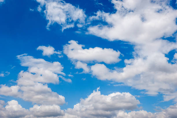 istock White fluffy clouds in the bright blue sky 2154895688