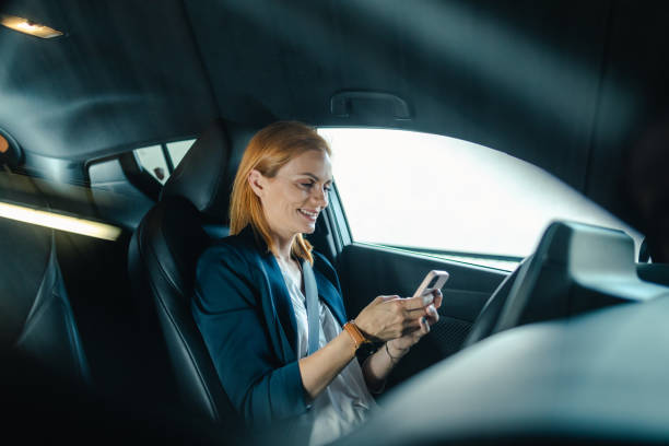 istock Businesswoman using smart phone in her car 2154897876