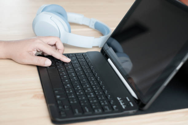 istock Woman hands are busy typing text using a compact black external keyboard with digital tablet 2154898227