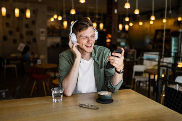 istock Man Enjoying Music on Phone at Cafe 2154898569