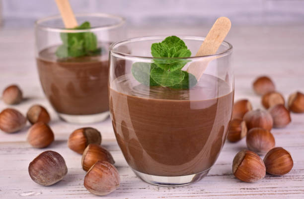 istock Chocolate mousse with hazelnut flavor and mint on a white wooden table. 2154898837